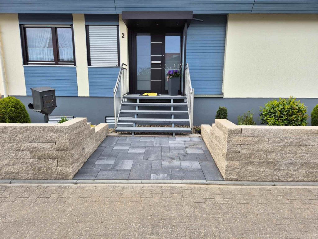 Zugang zu Haus mit Steinmauer und Metalltreppe, Schaffrin Garten und Landschaftsbau